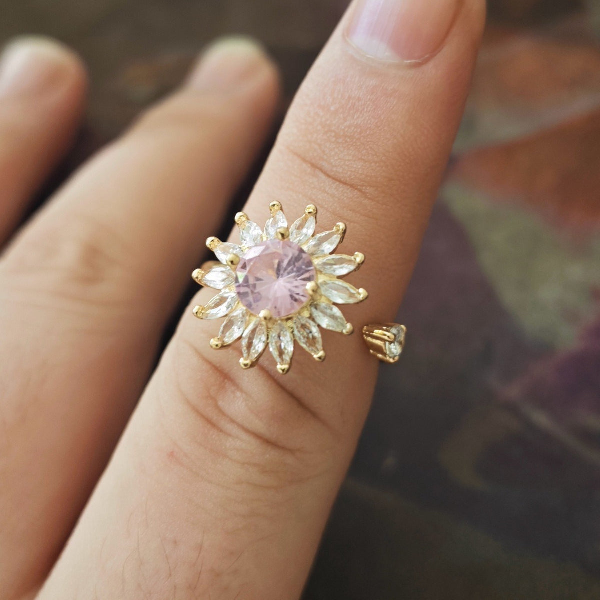 Anillo antiestrés girasol rosa puesto en el dedo
